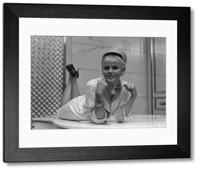 Framed Print : Actress Britt Ekland, holding a pendant from around her neck circa 1960s Framed Print : Actress Britt Ekland, holding a pendant from around her neck circa 1960s