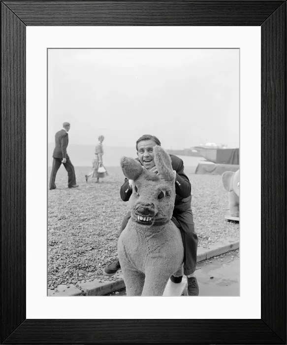 Framed Print : Actor and comedian Norman Wisdom photographed on Brighton Beach on a stuffed donkey Framed Print : Actor and comedian Norman Wisdom photographed on Brighton Beach on a stuffed donkey
