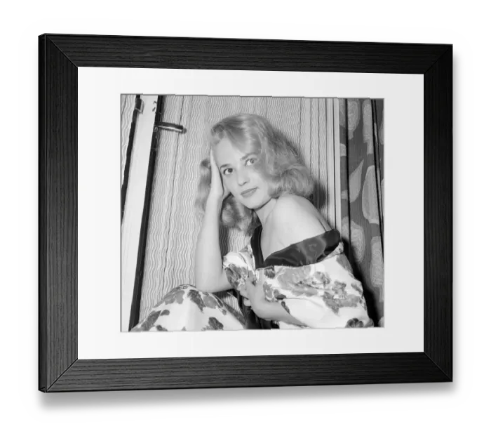 Framed Print : Actress Jeanne Moreau having her picture taken on a hotel bed July 1956