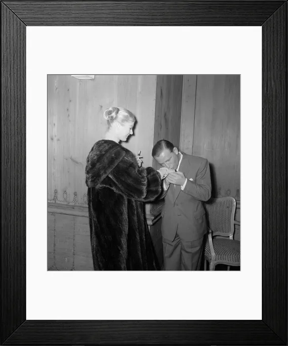 Framed Print : Actor and comedian Norman Wisdom kisses the hand of actress Anita Ekberg at the savoy