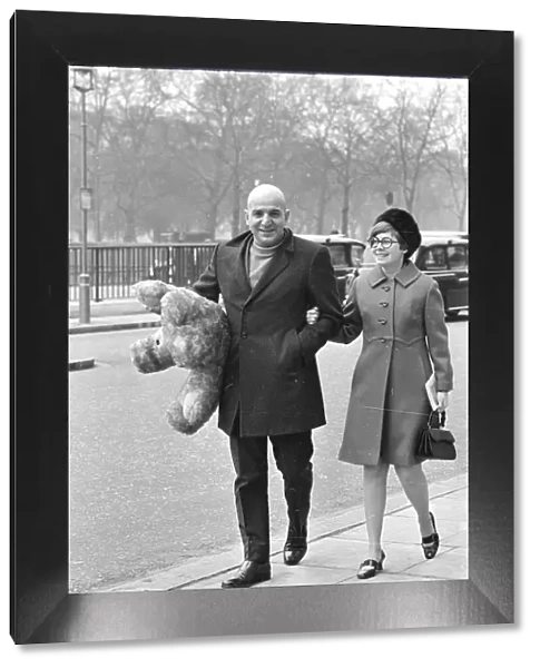 Actor Telly Savalas walking arm in arm in London with his wife, Marilynn Gardner