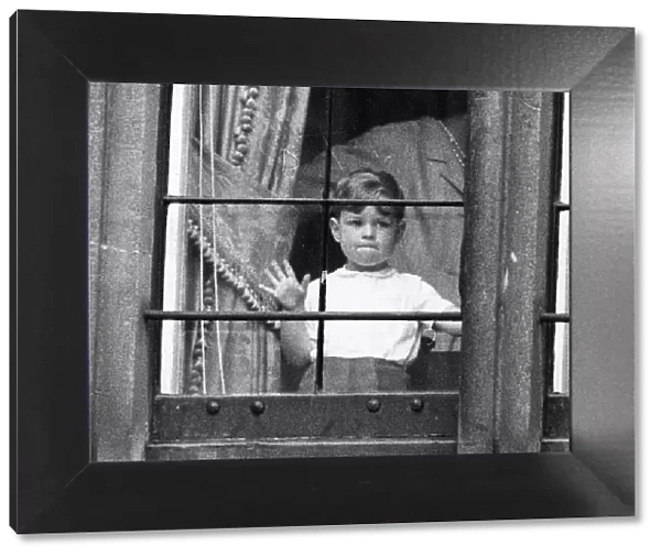 Prince Andrew as a boy behind window looking out of glass April 1963