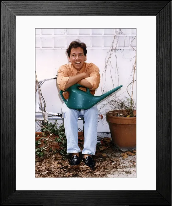 Framed Print : Ross King TV presenter in his garden holding a watering can Framed Print : Ross King TV presenter in his garden holding a watering can