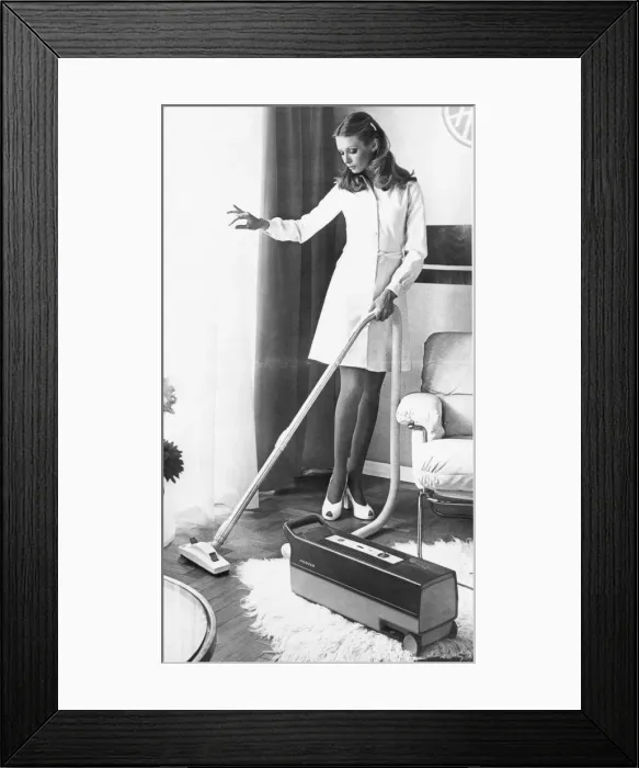 Framed Print : A housewife spring cleaning her lounge with a vacuum cleaner Framed Print : A housewife spring cleaning her lounge with a vacuum cleaner