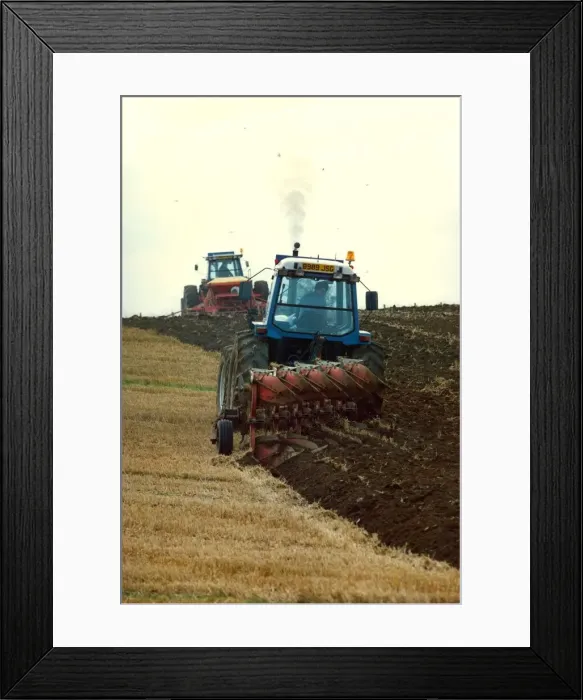 Framed Print : Tractors ploughing up a field Framed Print : Tractors ploughing up a field