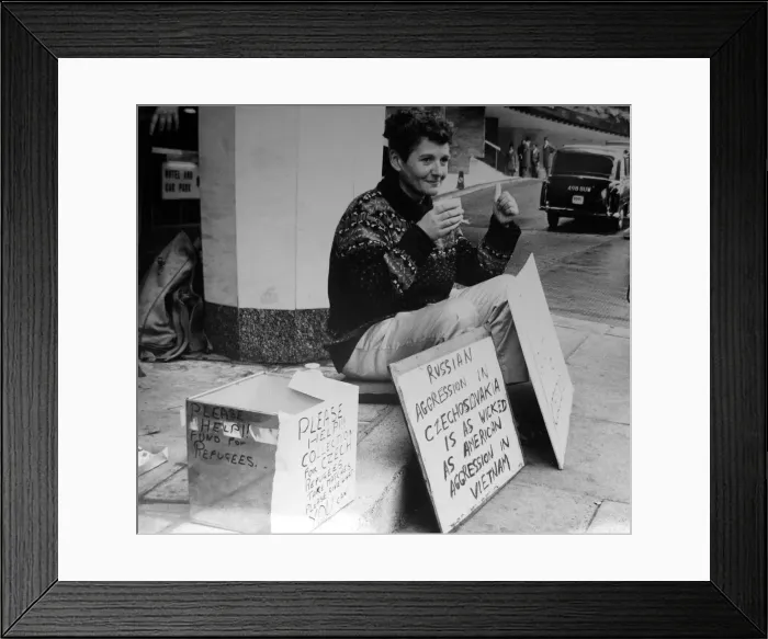 Framed Print : Pacifist campaigner Pat Arrowsmith sitting on the kerb with collection money outside