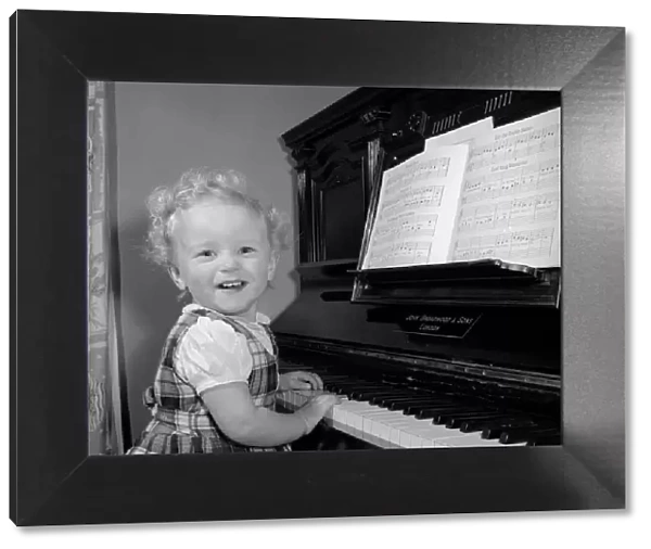 A small girl plays the piano Circa 1957