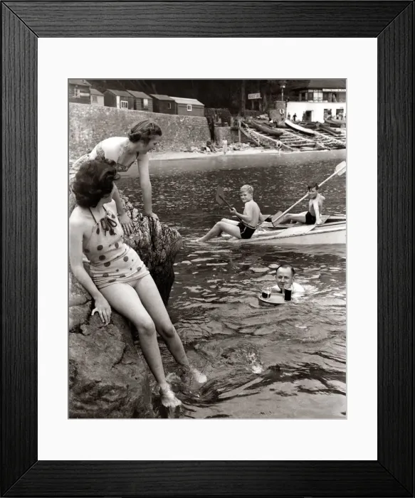 Framed Print : A family sitting on the rocks and playing in the water at Babbacombe Bay in Devon as a Framed Print : A family sitting on the rocks and playing in the water at Babbacombe Bay in Devon as a