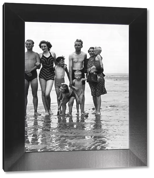 The photograph shows a family on the beach. September 1946 1940s