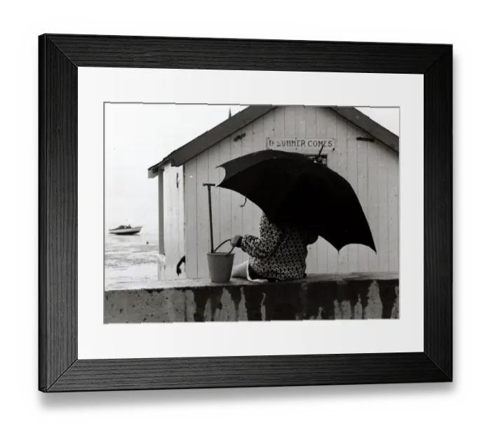 Framed Print : Thorpe Bay in Essex - April 1970 Holidaymaker on the beach with an umbrella Framed Print : Thorpe Bay in Essex - April 1970 Holidaymaker on the beach with an umbrella