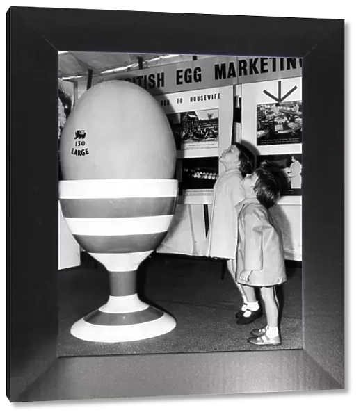 A giant egg brings amazement and wonder to the faces of two children at the British Egg