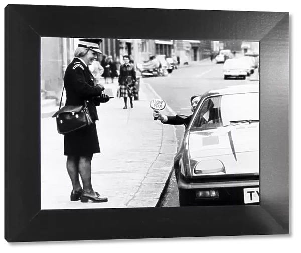 Writer Bryan Rimmer shows a traffic warden his sign. Local Caption ecard01