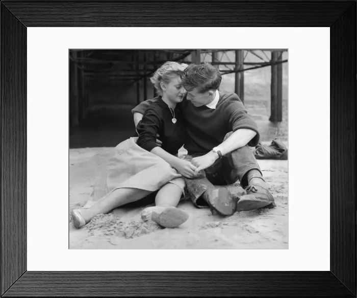 Framed Print : A young couple holding hands sitting on the beach. ecard01 Framed Print : A young couple holding hands sitting on the beach. ecard01