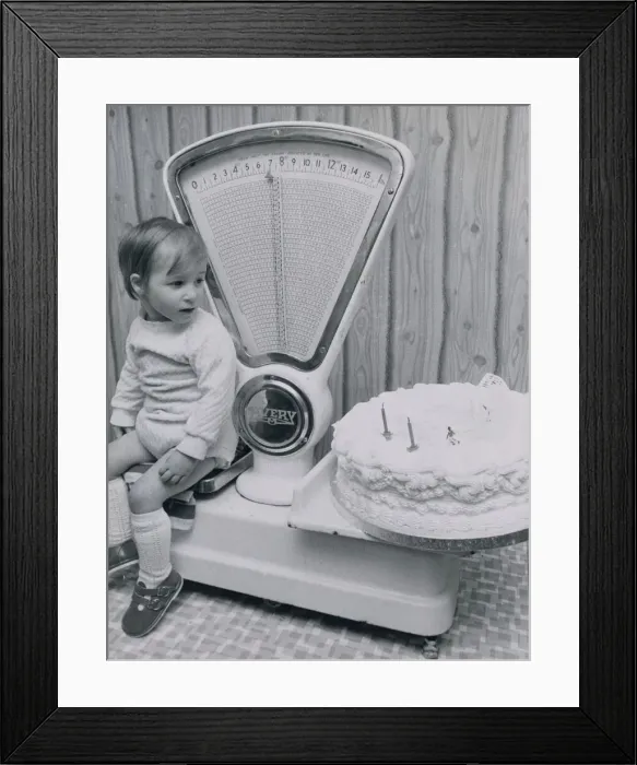 Framed Print : John McLean of West Lothian, Scotland checks his weight against his second birthday cake Framed Print : John McLean of West Lothian, Scotland checks his weight against his second birthday cake