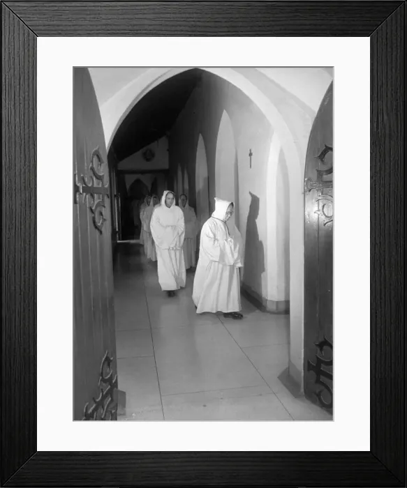 : Led by the Abbot, the Rt. Rev. Dom Malachy Brasil, monks file among the silent cloister : Led by the Abbot, the Rt. Rev. Dom Malachy Brasil, monks file among the silent cloister