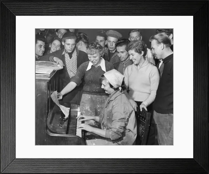Framed Print : Hungarian Refugees Refugees sing around a piano in a great common room