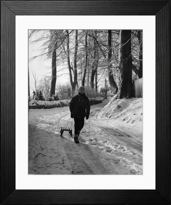 Framed Print : A young lad setting out with his toboggan in a country lane at St Nicholas Framed Print : A young lad setting out with his toboggan in a country lane at St Nicholas