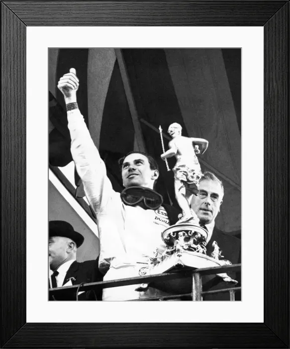 Framed Print : Jim Clark waves to the crowd as he holds the trophy presented to him by Earl Mountbatten