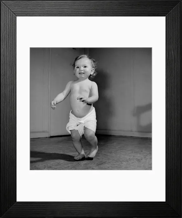 Framed Print : A 14 month baby toddles about the Baby Clinic before going in to the doctors surgery