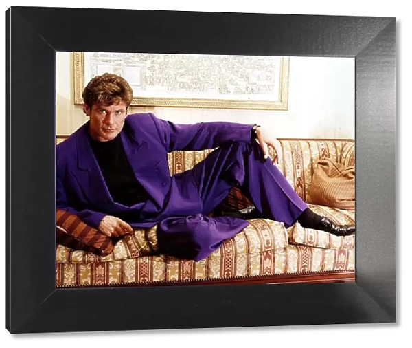 David Hasselhoff actor singer reclining on settee wearing purple suit