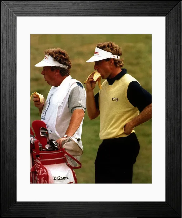 Framed Print : Berhard Langer Golf and his caddy take a break and eat a banana during a golf