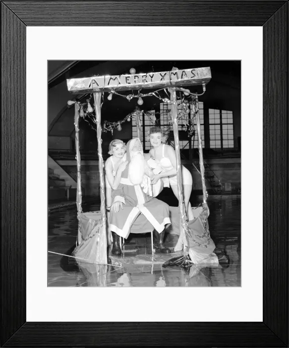 Framed Print : Father Christmas set adrift in a South London swimming pool with two bathing beauties Framed Print : Father Christmas set adrift in a South London swimming pool with two bathing beauties