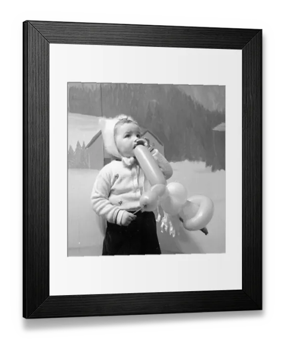 Framed Print : A little girl in a Manchester department store plays with her balloon after seeing Father