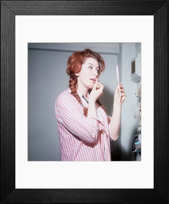 Framed Print : Heller Toren model actress 1964 puting on lipstick holding hand mirror pink striped shirt Framed Print : Heller Toren model actress 1964 puting on lipstick holding hand mirror pink striped shirt