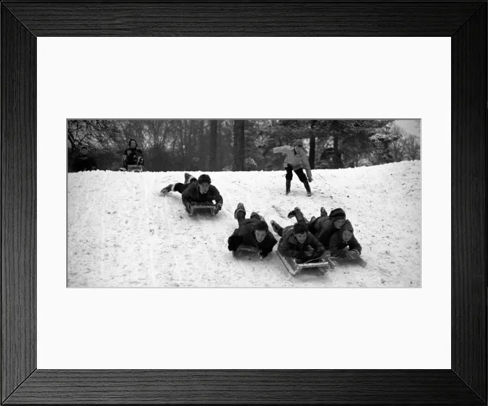 Framed Print : Young children make the most of the cold weather by going sledging at The Grove Framed Print : Young children make the most of the cold weather by going sledging at The Grove