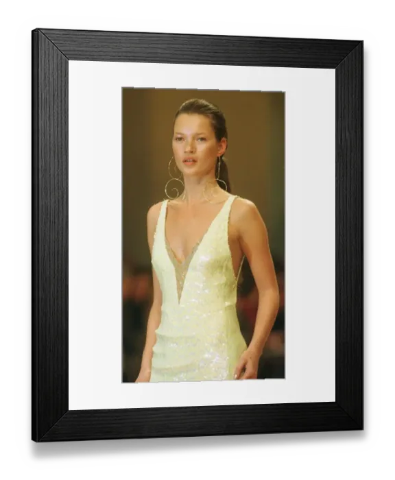 Framed Print : Kate Moss models for Chanel at Paris Fashion Week 1999 Wearing a low cut dress with