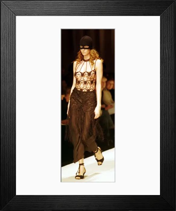 Framed Print : A model models a crochet top and ski mask March 1999 at the Moschino fashion show