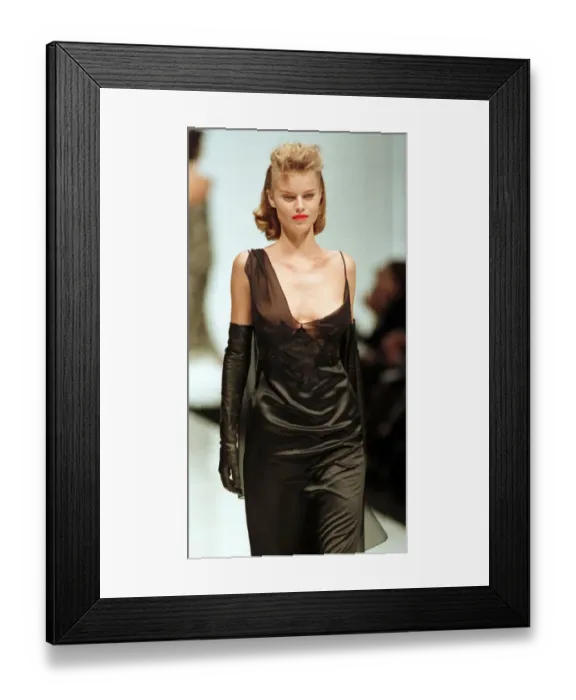 Framed Print : A model walks down the Catwalk October 1997 wearing a black evening dress during