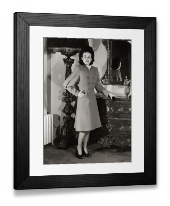 Framed Print : A model wearing a harella coat with new shaped sleeves and flared skirt standing beside a Framed Print : A model wearing a harella coat with new shaped sleeves and flared skirt standing beside a