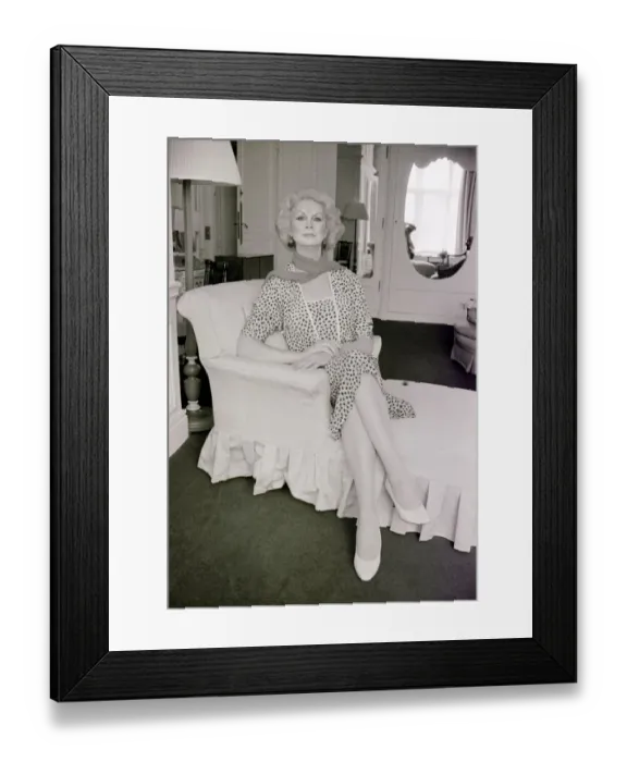 Framed Print : Sex change model April Ashley sitting on a recliner wearing a print dress hands clasped