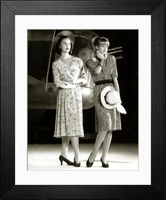 Framed Print : Two female models wearing 40s style evening dress with floral print holding a hat in one Framed Print : Two female models wearing 40s style evening dress with floral print holding a hat in one