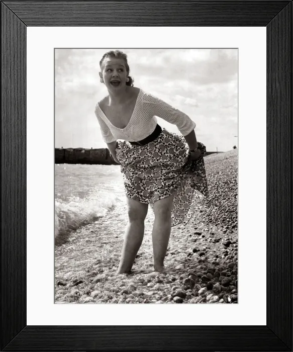 Framed Print : A girl wearing a flowery skirt and white top as she paddles in the waters of a shingle Framed Print : A girl wearing a flowery skirt and white top as she paddles in the waters of a shingle