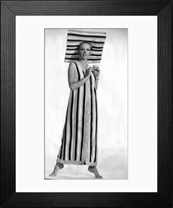 Framed Print : A model wearing six buttoned sleveless coat with a matching sun brim hat made in striped Framed Print : A model wearing six buttoned sleveless coat with a matching sun brim hat made in striped