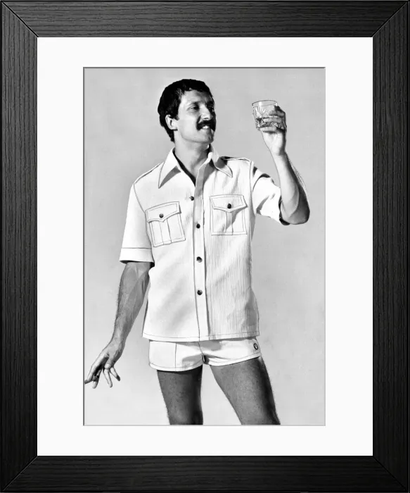 Framed Print : A man wearing a shirt with shorts looking at a glass of whisky Framed Print : A man wearing a shirt with shorts looking at a glass of whisky