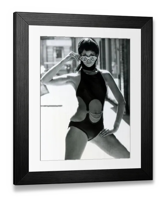 Framed Print : Fashion 1960s Model standing in the street wearing swimwear - a onepiece swimming