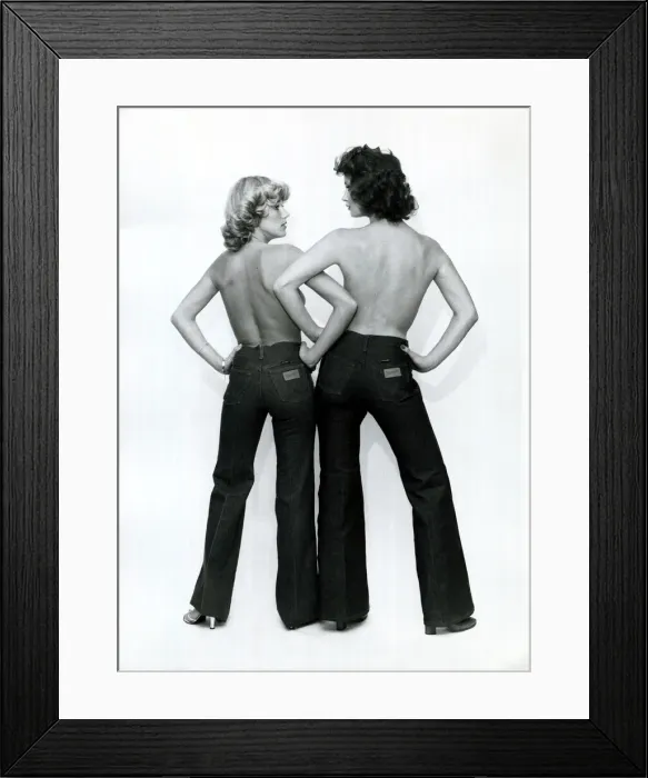 Framed Print : Fashion 1970s Models wearing Wrangler flared jeans, linking arms Framed Print : Fashion 1970s Models wearing Wrangler flared jeans, linking arms