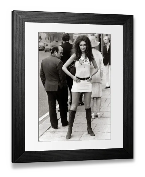 Framed Print : Female model Beulah Hughes wearing a mini dress and knee high boots in a London street as