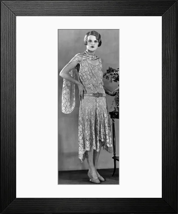 Framed Print : A model wearing a long patterned dress showing the popular uneven hemline in 1929