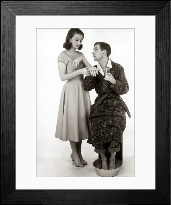Framed Print : A man wearing a dressing gown with his feet in a bowl of warm water drinking a glass of Framed Print : A man wearing a dressing gown with his feet in a bowl of warm water drinking a glass of