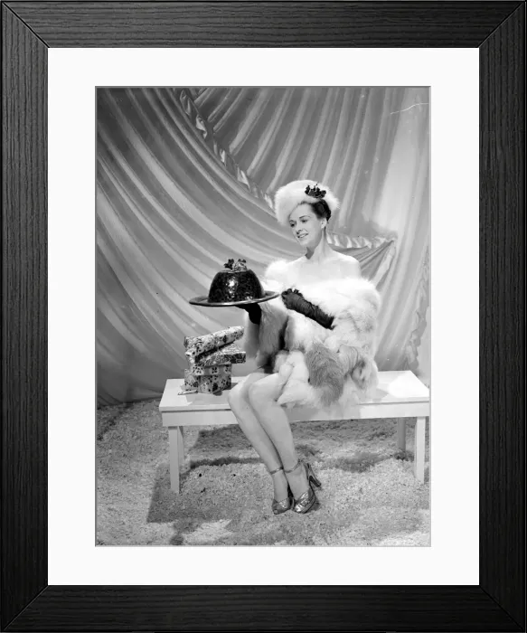 Framed Print : A model wearing fur hat wrap and glove holding a christmas pudding