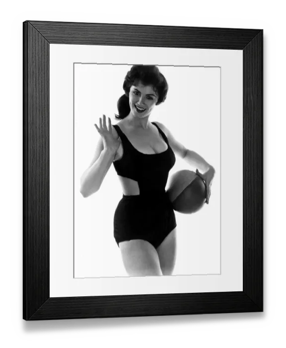 Framed Print : Fashion July 1958 Model from 1950s wearing a black swimsuit holding ball Framed Print : Fashion July 1958 Model from 1950s wearing a black swimsuit holding ball