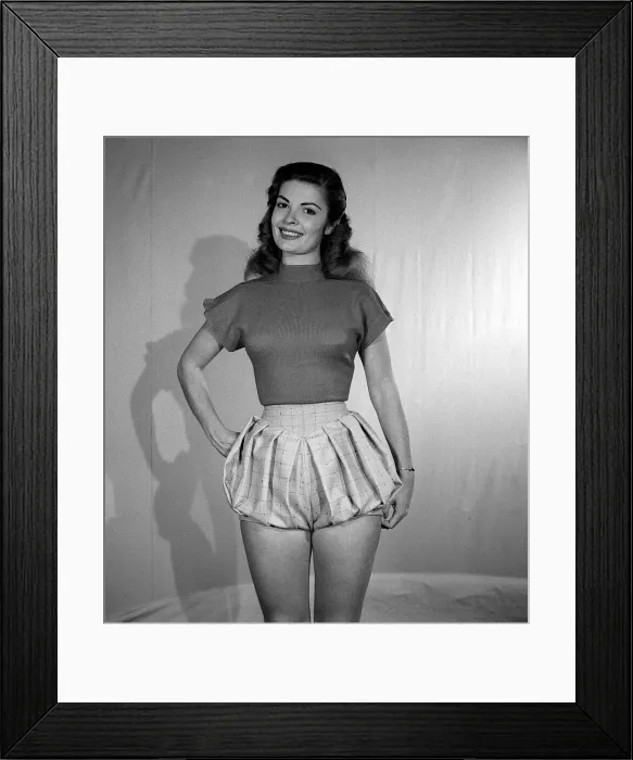 Framed Print : Model wearing bloomer slacks posing with one hand on her hip smiling at the camera Framed Print : Model wearing bloomer slacks posing with one hand on her hip smiling at the camera