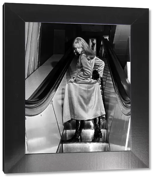 Fashion Coats Maxi January 1970 Woman on an escalator holding up her coat to show