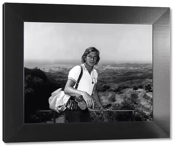 Motor racing driver James hunt on holiday in Spain 1975 with his golf clubs