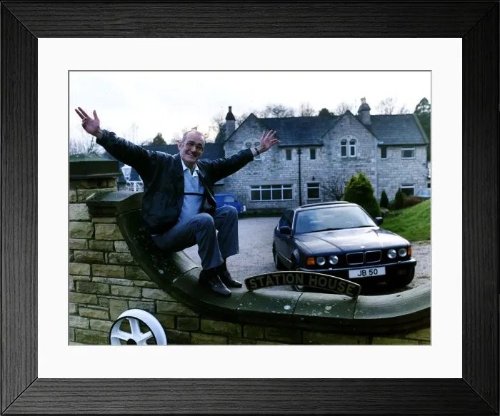 Framed Print : Jim Bowen comedian / TV presenter sitting on his garden wall with arms outstretched Framed Print : Jim Bowen comedian / TV presenter sitting on his garden wall with arms outstretched