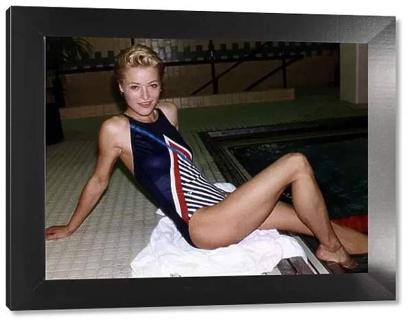 Amanda Donohoe British Actress sitting by the edge of a swimming pool with her feet in